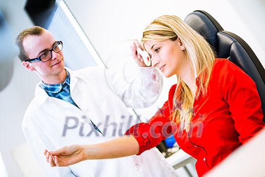 Optometry concept - pretty young woman having her eyes examined by an eye doctor (color toned image; shallow DOF) Optometry concept - pretty young woman having her eyes examined by an eye doctor (color toned image; shallow DOF)