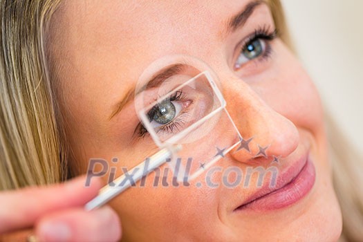 Optometry concept - pretty young woman having her eyes examined by an eye doctor (color toned image; shallow DOF) Optometry concept - pretty young woman having her eyes examined by an eye doctor (color toned image; shallow DOF)
