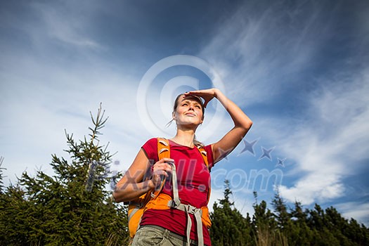 Pretty, female hiker going downhill in warm evening light Pretty, female hiker going downhill in warm evening light