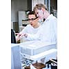 Two young researchers carrying out experiments in a lab (shallow DOF; color toned image)