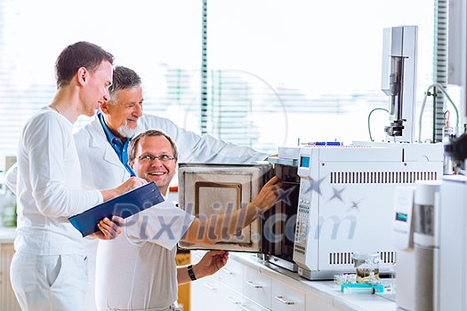 Team of researchers carrying out experiments in a lab (shallow DOF; color toned image) Team of researchers carrying out experiments in a lab (shallow DOF; color toned image)
