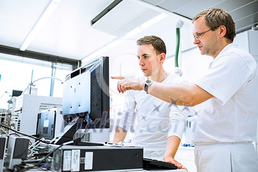 Team of researchers carrying out experiments in a lab (shallow DOF; color toned image) Team of researchers carrying out experiments in a lab (shallow DOF; color toned image)