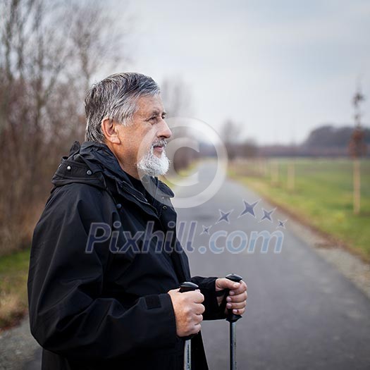 Senior man nordic walking, enjoying the outdoors, the fresh air, getting the necessary exercise Senior man nordic walking, enjoying the outdoors, the fresh air, getting the necessary exercise