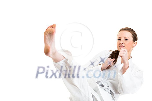 Beautiful caucasian, young, woman makes a kick in karate kimono on white background