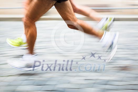 Motion blurred runner's feet in a city environment - running marathon (panning technique used -> motion blurred image; color toned image)