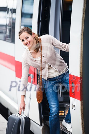Pretty young woman boarding a train (color toned image)