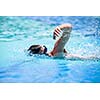 Young man swimming the front crawl in a pool