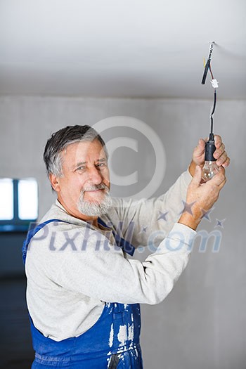 Senior man installing a bulb in a freshly renovated appartment Senior man installing a bulb in a freshly renovated appartment