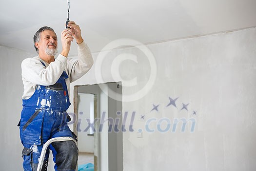 Senior man installing a bulb in a freshly renovated appartment