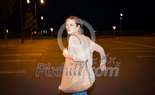 Scared young woman running from her pursuer in a deserted parking lot Scared young woman running from her pursuer in a deserted parking lot