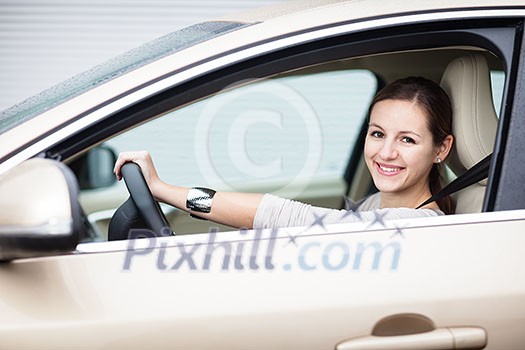 Pretty young woman driving her new car