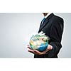 Close up of businessman holding Earth planet in palm. Elements of this image are furnished by NASA