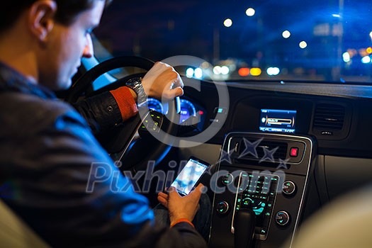 Driving a car at night -man driving his modern car at night in a city (shallow DOF; color toned image)