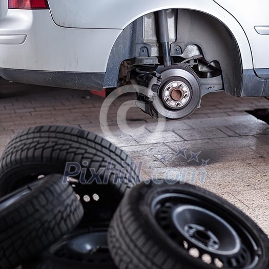 mechanic changing a wheel of a modern car (shallow DOF; color toned image)