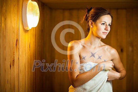Young woman relaxing in a sauna Young woman relaxing in a sauna