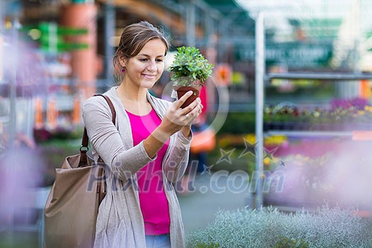 Young woman buying flowers at a garden center (color toned image; shallow DOF)
