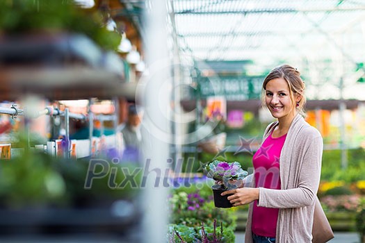 Young woman buying flowers at a garden center (color toned image; shallow DOF)