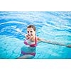 Portrait of a young woman relaxing in a swimming pool (shallow DOF; color toned image)