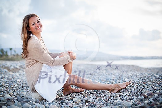 Young woman on the beach enjoying a warm summer evening Young woman on the beach enjoying a warm summer evening