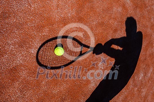 shadow of a tennis player in action on a tennis court (conceptual image with a tennis ball lying on the court and the shadow of the player positioned in a way he seems to be playing it) shadow of a tennis player in action on a tennis court (conceptual image with a tennis ball lying on the court and the shadow of the player positioned in a way he seems to be playing it)