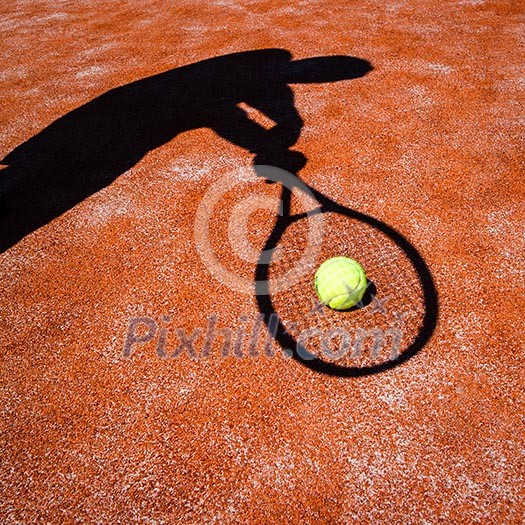 shadow of a tennis player in action on a tennis court (conceptual image with a tennis ball lying on the court and the shadow of the player positioned in a way he seems to be playing it) shadow of a tennis player in action on a tennis court (conceptual image with a tennis ball lying on the court and the shadow of the player positioned in a way he seems to be playing it)