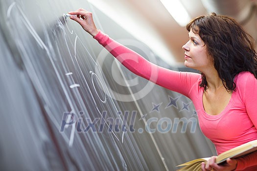 Pretty young elementary school/college teacher writing on the chalkboard/blackboard during a chemistry class (color toned image; shallow DOF) class (color toned image; shallow DOF) Pretty young elementary school/college teacher writing on the chalkboard/blackboard during a chemistry class (color toned image; shallow DOF) class (color toned image; shallow DOF)