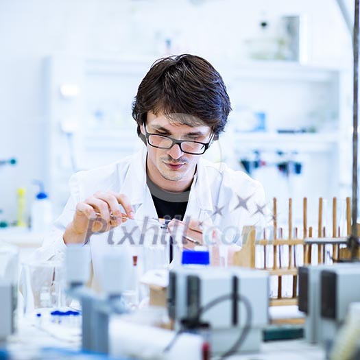 Young male researcher carrying out scientific research in a lab (shallow DOF; color toned image) Young male researcher carrying out scientific research in a lab (shallow DOF; color toned image)