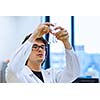 Young male researcher carrying out scientific research in a lab (shallow DOF; color toned image)