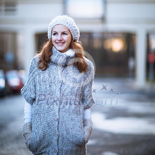 Autumn/winter portrait: young woman dressed in a warm woolen cardigan posing outside in a city park Autumn/winter portrait: young woman dressed in a warm woolen cardigan posing outside in a city park