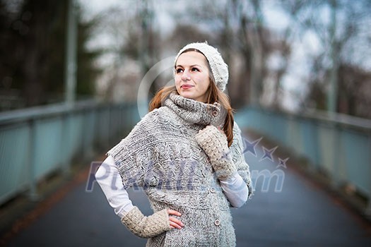 Autumn/winter portrait: young woman dressed in a warm woolen cardigan posing outside in a city park Autumn/winter portrait: young woman dressed in a warm woolen cardigan posing outside in a city park