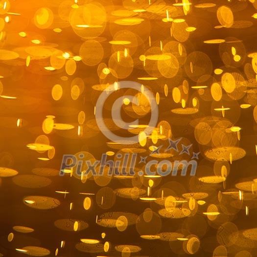 Golden macro background: gas bubbles in beer at shallow DOF against sunlight