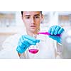 close-up portrait of a young male researcher carrying out experiments in a chemistry research lab (color toned image)