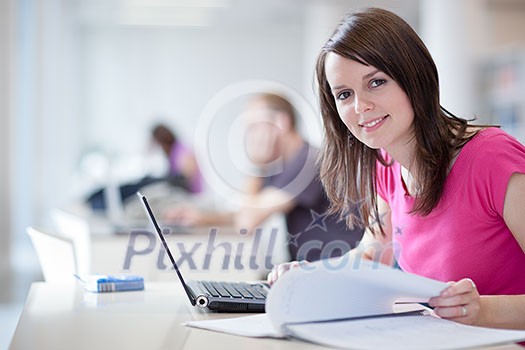 in the library - pretty female student with laptop and books working in a high school library  (color toned image)