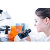 portrait of a female researcher doing research in lab using microscope (color toned image; shallow DOF)