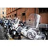 Row of motorbikes and scooters parked in one of the ancient streets of Rome
