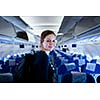 Pretty young female passenger on board of an aircraft (color toned image)