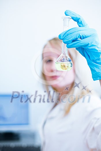 Closeup of a female researcher/chemistry student carrying out experiments in a lab (color toned image) Closeup of a female researcher/chemistry student carrying out experiments in a lab (color toned image)