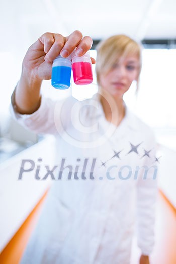 Closeup of a female researcher/chemistry student carrying out experiments in a lab (color toned image) Closeup of a female researcher/chemistry student carrying out experiments in a lab (color toned image)