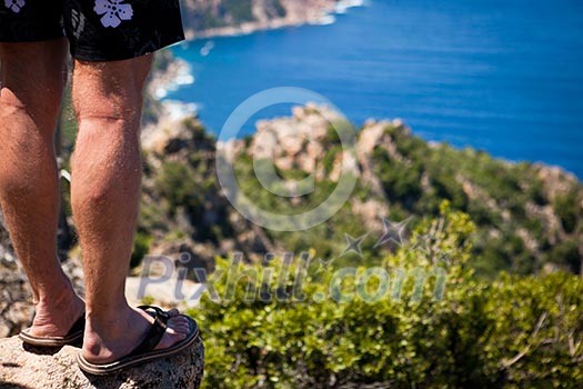 Traveler standing on a cliff (Porto region, Corsica, France)
