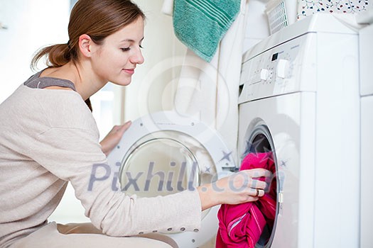 Housework: young woman doing laundry (shallow DOF; color toned image)