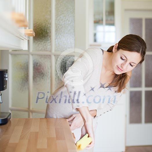 Young woman doing housework, cleaning the kitchen Young woman doing housework, cleaning the kitchen