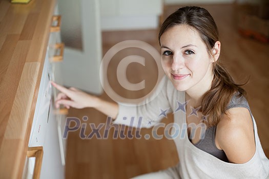 Housework: young woman using a dishwasher