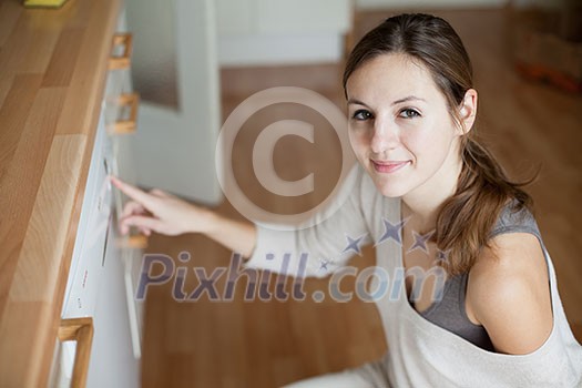 Housework: young woman using a dishwasher Housework: young woman using a dishwasher