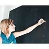 pretty young college student/young teacher writing on the chalkboard/blackboard during a math class (color toned image; shallow DOF)