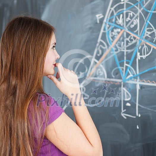 pretty young college student writing on the chalkboard/blackboard during a math class (color toned image; shallow DOF)