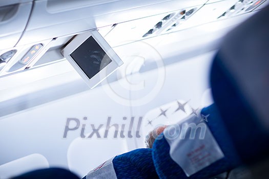 Interior of an aircraft (selective focus on seat numbers and air conditioning)