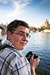 Young tourist taking pictures near the Charles Bridge in Prague, Czech Republic