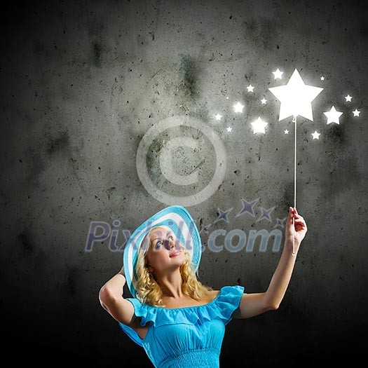 Young pretty woman in blue hat and dress holding balloon