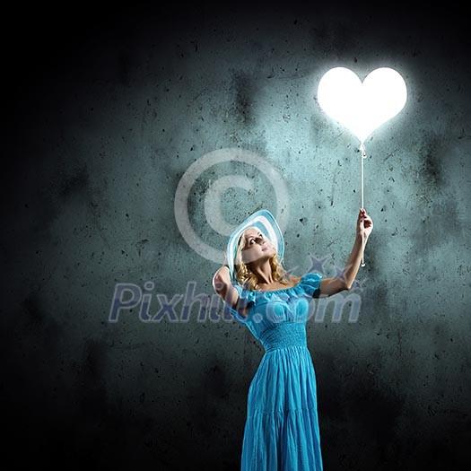 Young pretty woman in blue hat and dress holding balloon Young pretty woman in blue hat and dress holding balloon