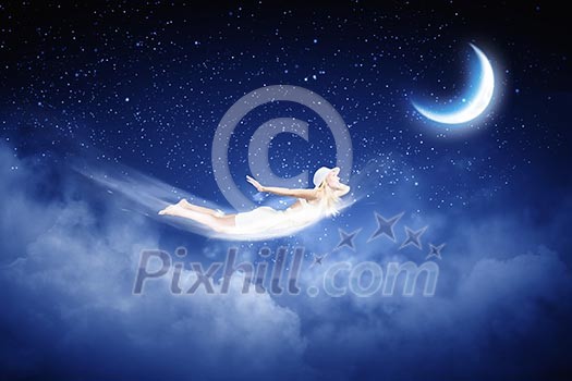 Young blond girl flying in night sky